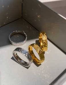 Close-up of gold and silver hammered texture open rings with artistic lighting