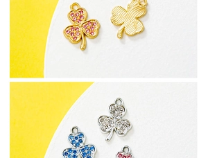 Close-up of gold and silver four-leaf clover charms with inlaid pink and blue zircons