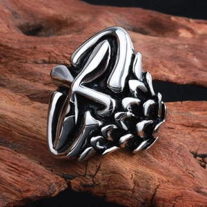 Detailed view of silver cross ring with abstract pinecone texture on wood bark
