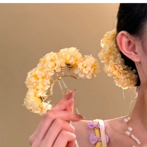 Detail of warm yellow fabric flower hairpin with delicate pearls and metal base