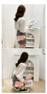 Three-tone pastel crossbody bag with gold chain strap shown on a model in minimalist studio