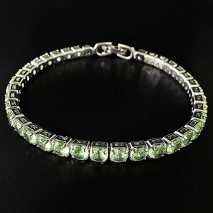 Dettaglio del bracciale tennis in argento con pietre verde menta su fondo nero riflettente