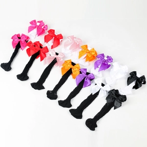 Twelve pairs of girls' mesh fishnet socks with colorful satin bows on a white background
