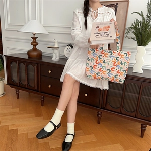 Chic quilted tote bag with colorful geometric pattern held by a model in a cozy setting