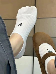 White ribbed ankle socks with black bow embroidery worn with brown Mary Jane shoes