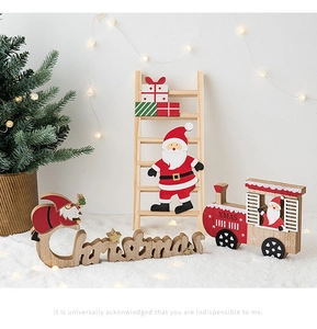Detail of wooden Christmas ornaments featuring Santa Claus, a ladder, and XMAS train decor