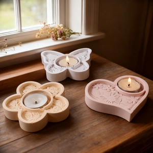 Detailed relief flower heart and butterfly resin tea light candle holders on wooden windowsill