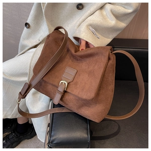 Dettaglio della texture in pelle scamosciata marrone opaca e fibbia di una borsa