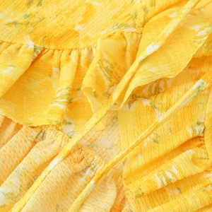 Macro shot of yellow floral fabric with pleated texture and ruffle trim for women's blouse