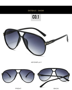 Detail of pilot sunglasses showing golden T-shaped metal hinge and gradient grey lenses