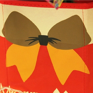 Close-up of red non-woven Christmas tree stand cover with yellow bow print and stitching