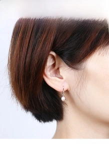 Close-up of S925 silver natural freshwater pearl earrings worn on a female model's ear