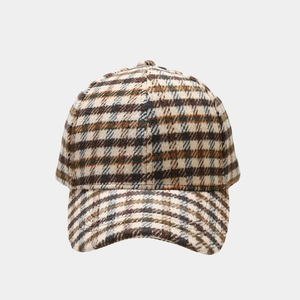 Detail shot of vintage plaid patterns on a warm tweed baseball cap with reinforced stitching