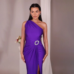Detail view of purple one-shoulder dress featuring a sparkling rhinestone waist buckle