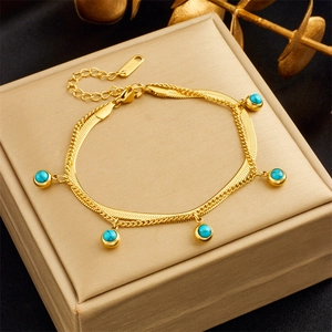 Detailed view of golden stainless steel bracelet with five blue turquoise bead pendants