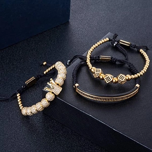 Three-piece gold and black crown bracelet set with zircon stones on a luxury gift box