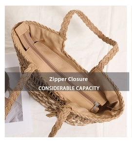 Detail showing the metal zipper closure and brown fabric lining of the straw tote bag
