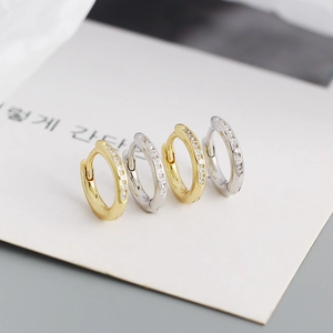 Macro shot of gold and silver S925 geometric hoop earrings with small cubic zirconia stones