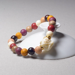 Detailed shot of Buddhist beads bracelet with lion carving on a white ceramic lid