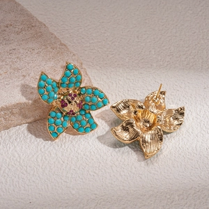 Detail of vintage flower stud earrings with turquoise beads and golden metal finish