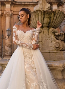 Détails de broderie en dentelle florale sur les manches d'une robe de mariée blanche