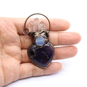 Detailed macro of handmade copper heart pendant with amethyst and quartz crystals