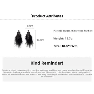 Détail de boucles d'oreilles longues en plumes avec strass noirs et base en cuivre