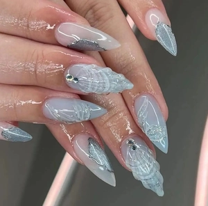 Close-up of 3D shell relief and silver marble texture on long stiletto press-on nails