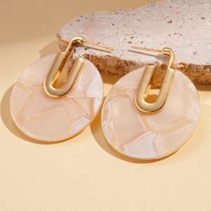 Close-up of 18K gold plated round earrings with beige marble texture acetate pendant
