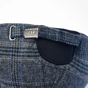 Close-up of wool plaid baseball cap with adjustable metal buckle and elastic band
