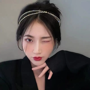 Detail view of a double-layered silver headband with sparkling white rhinestones on model