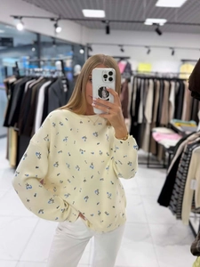 Relaxed fit cream yellow knit sweater with blue floral pattern and round neck design