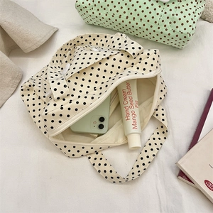 Close-up of polka dot canvas travel bag with zip closure and spacious inner storage