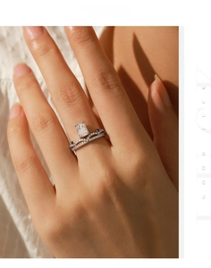 Detail of s925 silver ring set with emerald cut stone and V-shaped diamond band