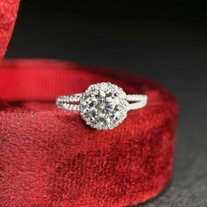 Macro view of a 925 silver moissanite ring with halo setting on a red velvet box