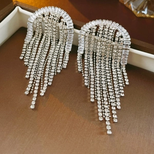 Macro shot of silver tassel earrings with zircon fringe details on a jewelry box