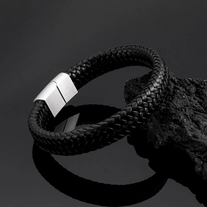 Macro shot of men's black braided leather bracelet with brushed metal magnetic clasp
