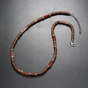 Detailed shot of ethnic necklace featuring brown wood beads and reddish stones with silver clasp