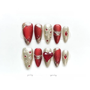 Oxblood red cat-eye press-on nails with golden heart gemstones and sparkling glitter accents