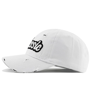 Detail of white cotton baseball cap with black Classic embroidery and distressed accents