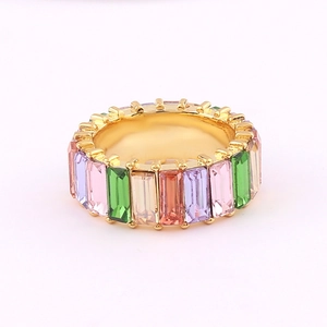 Macro view of multi-color square zircon stones set in a gold-plated copper ring band