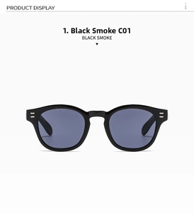 Detail of black thick frame sunglasses with silver rivet accents and smoke lenses
