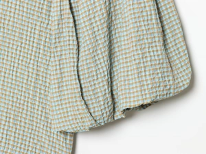 Detail von blau-beige kariertem Seersucker-Stoff mit strukturierter Oberfläche