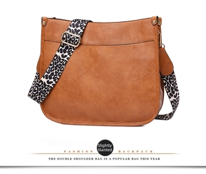 Brown faux leather saddle bag with leopard print strap and gold hardware detail