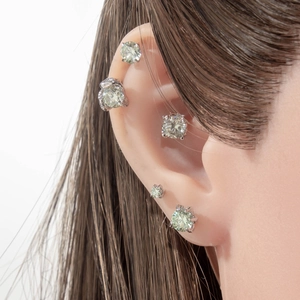 Silver stud earrings with round mint green cubic zirconia stones on model ear