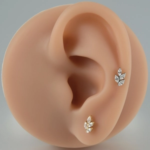 Macro view of gold and silver F136 titanium marquise-cut zircon flower labret studs