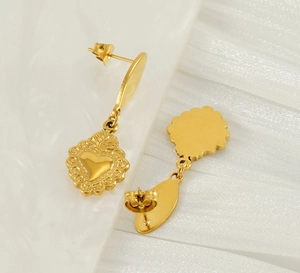 Detail of vintage heart-shaped gold-plated stud earrings with radiant borders