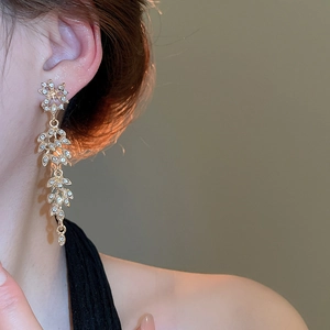 Gros plan détaillé de boucles d'oreilles pampilles à feuilles de cristal dorées