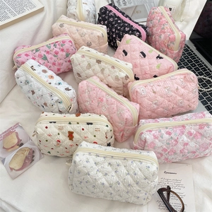 Detailed view of quilted cotton cosmetic bags in various cute floral and bear patterns