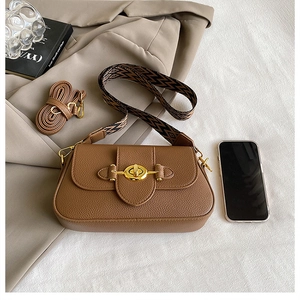 Détail du sac bandoulière marron en cuir grainé avec sangle géométrique et fermoir doré